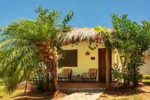 ein kleines Haus mit einem Strohdach und einer Veranda in der Unterkunft Mbuni Granja de Avestruz in Nueva Colombia