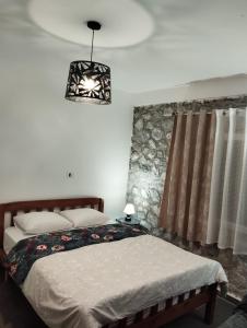 a bedroom with a bed and a chandelier at Bujtina Aroma E Malit in Valbonë