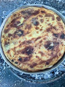 a pizza in a pan on a table at Bujtina Aroma E Malit in Valbonë