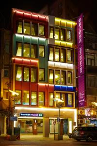 台北市にあるV ワン ホテル 寧夏 No. 2 インの夜間にカラフルな照明が灯る高層ビル