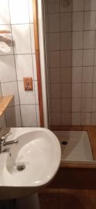 a bathroom with a white sink and a tub at Maison de village avec jardin in Saint-Louis-et-Parahou