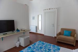 a living room with a television and a chair at Casa Chicchella - Authentic Experience in Vieste