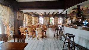 a restaurant with tables and chairs and a bar at Hôtel La Fontaine in Saint-Imier