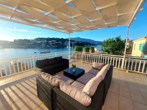a couch on a deck with a view of the water at Apartments Villa Julija in Lumbarda
