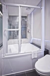 y baño con bañera, aseo y ducha. en V-one Hotel - Ningxia No. 2 Inn en Taipéi
