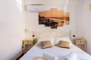 A bed or beds in a room at TEMPIO DI APOLLO - ORTIGIA con Veranda Privata