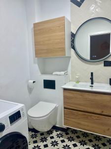 a bathroom with a toilet and a sink and a mirror at Casa Leo in Almería