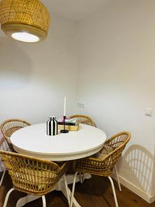 a white table with chairs and a candle on it at Casa Leo in Almería
