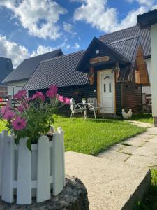 a house with a white fence in front of it at Apartment & Rooms Sweet Dreams in Žabljak
