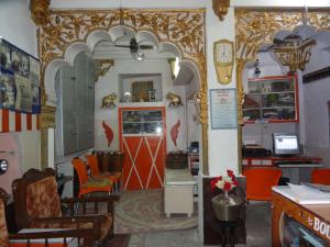 a restaurant with orange chairs and a red door at Amar Niwas Homestay Guesthouse in Jodhpur