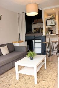 a living room with a couch and a table at Le Petit Moulin in Gradignan