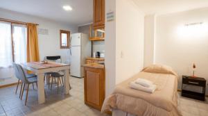 a small kitchen with a table and a bed in a room at Happy Guest Apart 87 in Ushuaia