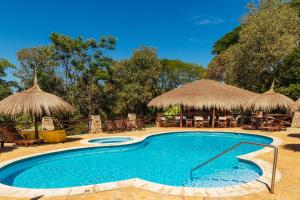 ein Swimmingpool mit Stühlen und Sonnenschirmen in der Unterkunft Mbuni Granja de Avestruz in Nueva Colombia