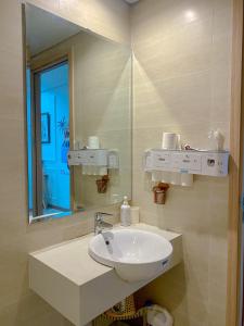 a bathroom with a sink and a mirror at Boom'homes- Căn hộ view Vịnh Hạ Long in Ha Long +3 photos