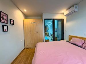a bedroom with a bed with a pink blanket at Boom'homes- Căn hộ view Vịnh Hạ Long in Ha Long