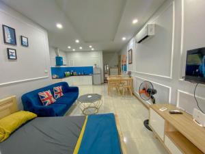 a living room with a blue couch and a kitchen at Boom'homes- Căn hộ view Vịnh Hạ Long in Ha Long