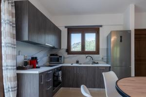 a kitchen with wooden cabinets and a table and a window at Atalaya Villa in Stalís