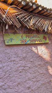 a sign on a wall with graffiti on it at casa84 in Barra de São Miguel +12 photos