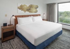 a large bed in a hotel room with a large window at Hilton Fairfax, Va in Fairfax