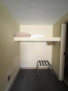 a room with a shelf and a chair on a wall at Hillside Lodge in Lake Junaluska