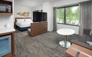 a hotel room with a bed and a flat screen tv at Hilton Fairfax, Va in Fairfax