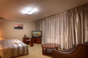 a hotel room with a bed and a table and a window at Voyage Hotel in Almaty