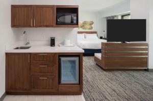 a hotel room with a kitchen and a bed at Hilton Fairfax, Va in Fairfax