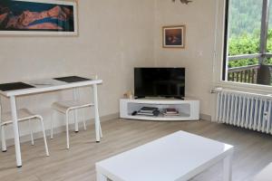 sala de estar con mesa blanca y TV en studio residence Grands Montets, en Chamonix-Mont-Blanc 9 fotos más