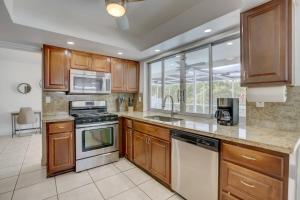 a kitchen with wooden cabinets and a stove top oven at Sunrise Family Oasis Pool Lake Canal Views in Sunrise