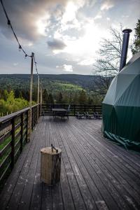 eine Holzterrasse mit Tisch und Zelt in der Unterkunft BUNNY GLAMP in Korbielów
