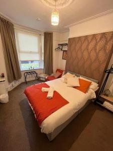 a bedroom with a large bed with a red blanket at Rooms Anfield- 5 mins from LFC in Liverpool