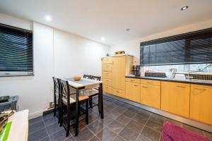 Una cocina con gabinetes de madera y una mesa con sillas. en COMFORTABLE SPARE ROOM with KING SIZE BED, Near Sheffield Centre, en Heeley 13 fotos más