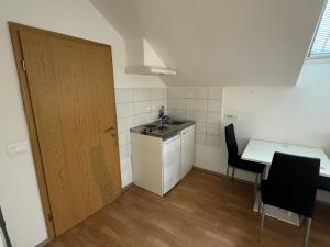 a small kitchen with a table and a door at Apartments Park Vodice - Ljubljana, Krvavec in Woditz +73 photos