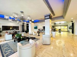 a large living room with white furniture and a chandelier at Beach Front Condo, Sea View, Beach Access, Balcony in Fort Lauderdale +74 photos