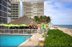 a swimming pool next to a beach and some buildings at Beach Front Condo, Sea View, Beach Access, Balcony in Fort Lauderdale