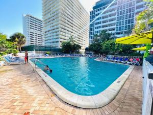 a large swimming pool in a city with tall buildings at Beach Front Condo, Sea View, Beach Access, Balcony in Fort Lauderdale