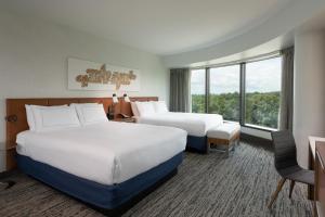 a hotel room with two beds and a window at Hilton Fairfax, Va in Fairfax