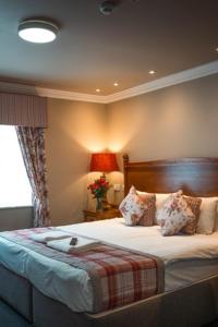 a bedroom with a large bed and a window at The Atherstone Red Lion Hotel in Atherstone