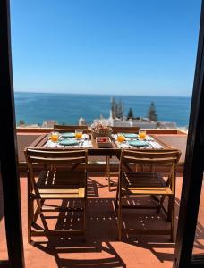 un tavolo con cibo e 2 sedie su un balcone di Luz Ocean View Apartment a Luz