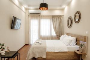 een slaapkamer met een bed met witte lakens en een raam bij The Clock House in Veria