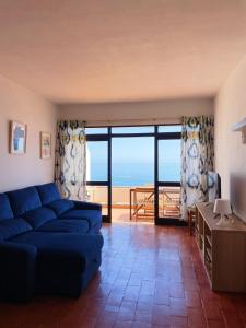 un soggiorno con divano blu e vista sull'oceano di Luz Ocean View Apartment a Luz
