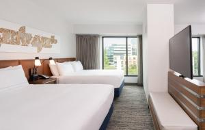 a hotel room with two beds and a tv at Hilton Fairfax, Va in Fairfax