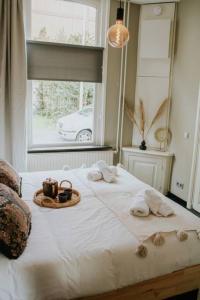 a bedroom with a bed with towels and a window at Boutique 2br Apt With Garden At Fontys in Tilburg +28 photos