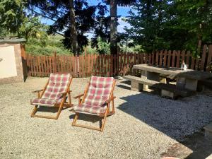 two lawn chairs and a picnic table in a backyard at La Casetta della valle di Civita in Bagnoregio