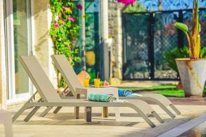 two white chairs sitting on a patio with a table at Rüzgargülü Otel in Alacati