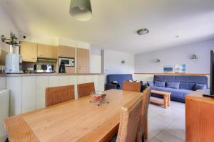 eine Küche und ein Wohnzimmer mit einem Holztisch und Stühlen in der Unterkunft Résidence Belle Dune - maeva Home - Appartement 3 pièces 6 personnes - Sélection MAE-9634 in Fort-Mahon-Plage + 14 Fotos