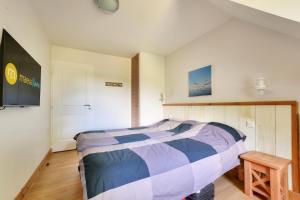 ein Schlafzimmer mit einem Bett und einem Fernseher an der Wand in der Unterkunft Résidence Belle Dune - maeva Home - Appartement 3 pièces 6 personnes - Sélection MAE-9634 in Fort-Mahon-Plage