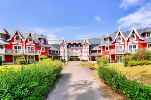 ein großes rotes Haus mit einem Weg davor in der Unterkunft Résidence Belle Dune - maeva Home - Appartement 3 pièces 6 personnes - Sélection MAE-9634 in Fort-Mahon-Plage