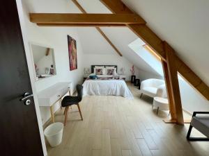 a bedroom with a bed and a desk in a attic at Villaveyron in Roussennac +27 photos