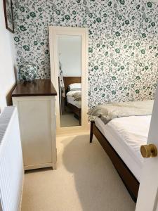 a bedroom with a bed and a mirror at Cosy 3 bedroom home, 2 minutes from the beach in Perranporth